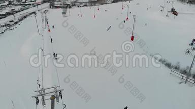 滑雪者和滑雪者在滑雪场的山上爬山。 空中观景。 4K